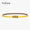 Slim yellow leather belt for women featuring a wavy gold buckle and adjustable strap - Yellow