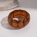 Close-up of brown amber-toned acrylic bead bracelet with golden glitter and elastic cord - Dark Coffee