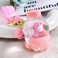 Close-up of pink liquid keychain with cartoon alpaca, pink bell, and soft wrist strap - Lamb Peach Soda Bottle