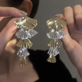 Macro detail of tiered metal fan-shaped dangle earrings with ribbed texture design - Five-layer Fan Stacked / Gold