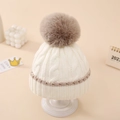 Detalle del gorro de punto para bebé en crema y marrón con un suave pompón - 0-12 Meses / Caqui (Blanco roto con pompón marrón)