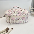 Gros plan d'une trousse à maquillage matelassée avec imprimés chiens et ruban blanc - Paradis des Chiots