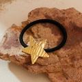 Haargummi mit goldenem Sternanhänger auf Naturstein für einen eleganten Look - Stern