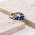 Macro detail of retro steel ring with blue emerald-cut stone and spiral texture - Steel with Blue Zirconia