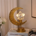 Detail der goldenen Mondlampe mit LED-Stern auf einem Schreibtisch mit warmem Licht - Mondlampe Kunststoff Stern Stil / Warmweiß