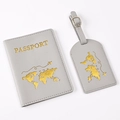 Close-up of gray PU leather passport cover and luggage tag with gold world map stamp - Light Grey Map