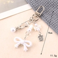 Detail view of a resin butterfly pearl pendant with star charms and metal clasp - Small Pendant / White Bowknot Letter Tag Charm(K4612)