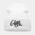 Detailed close-up of white knitted beanie with black Gigi cursive letter embroidery - One Size / White