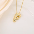 Detail of gold bubble letter F pendant with colorful zircons on silk background - Letter F