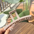 Detail of a large creamy lotus pink hair claw clip showing its strong metal spring and matte finish - Greek-letter Shaped Extra Large Butterfly Buckle / Stone Grey (Approx 13.5cm)