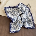Close-up of knotted floral headband with blue print and contrast stitching detail - Large Floral White Scrunchie