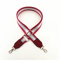 Close-up of adjustable striped wide bag strap with metallic thread and gold hardware - Red