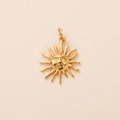 Detailed close-up of a 18K gold-plated stainless steel sun pendant with a smiling face - Sun