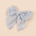 Dettaglio di un fermaglio per capelli in pizzo azzurro con fiocco traforato elegante - Azzurro