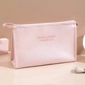 Pink PU leather travel makeup bag with handle and embossed text on soft beige background - Pink-Large