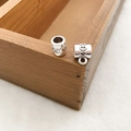 Gros plan de perles argentées avec cœurs gaufrés et connecteur pour bijoux DIY - 1 connecteur 3 voies 8x11mm Motif Cœur