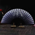 Detailed close-up of a folding fan with cherry blossoms on a wooden display stand - Ink Falling Cherry Blossoms