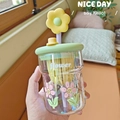 Detailed view of floral glass cup with light green lid and yellow flower straw decoration - 500ml / Green