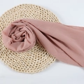 Elegant dusty rose chiffon hijab scarf neatly displayed on a rustic circular straw mat - 81