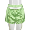 Dettaglio degli shorts in raso verde con design traforato e fibbie con coulisse regolabili - S / Verde