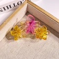 Pink and yellow gradient resin plumeria flower hair claw clip on a gold-rimmed beige tray - Triple Flower Gradient Yellow