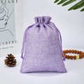 Purple linen drawstring pouch for jewelry storage and gift packaging on white surface - Purple