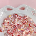 Detailed macro view of iridescent acrylic beads with flower smiley faces in a ceramic tray - Red Sun + Umbrella / 18mm