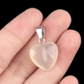 Pendentif cœur en quartz beige translucide avec bélière argentée sur le bout du doigt - Agate