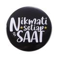 Round black tinplate badge with white Nikmati setiap SAAT quote and yellow stars - Nikmati setiap SAAT