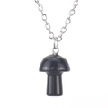 Vue macro d'un pendentif champignon noir poli de 2cm sur une fine chaîne en métal argenté - Obsidienne