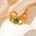 Détail d'une bague dorée ajourée en cœur avec une pierre précieuse verte sur soie - Bague Ouverte Cœur Pierre Verte