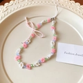 Handy-Anhänger mit rosa Schleife, Blumenperlen und pastellfarbenen Kristallen auf Tablett - Rosa Blumen Schleife Handyband