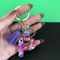 Letter P resin keychain with purple tassel, gold hardware, and blue star sequins - Letter P