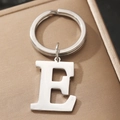 Polished silver metal keychain with uppercase letter E pendant on textured background - Letter E