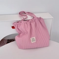 Macro shot of pink pleated tote bag texture and branded woven label detail on fabric - Pink