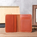 Detail view of handmade brown leather wallet with multiple card slots on wooden desk - 1052 Orange Red