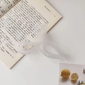 Detalle de pinza para el pelo con lazo blanco traslúcido mate sobre un libro abierto - 11cm / Lazo Mate Blanco