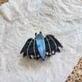 Macro shot of Halloween bat hair claw clip with black wings and blue glitter details - Cute Bat