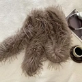 Vista detallada de la textura de plumas gris pardo en una bufanda de felpa de lujo - Camel con flecos largos