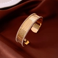 Detailed view of golden wide open bangle with pave-set crystals and textured stripes - Gold