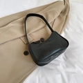Minimalist black baguette underarm bag in premium PU leather on a camel blazer - Black
