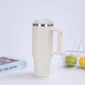 Detail of a cream 40oz insulated tumbler with ergonomic handle and straw in a minimalist setting - Off-White (Generation 2)