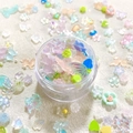 Detailed view of mixed resin charms including flowers, butterflies and hearts for nail art - Small Round Boxed