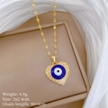 Makro-Detail des goldenen Evil-Eye-Herzanhängers mit Kristallen auf einer Box - Böser Blick Herzanhänger (K526 Titanstahlkette Kupfer-Mikropavé)