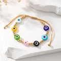 Detail of bohemian evil eye bracelet with colorful beads and adjustable gold cord - Colorful
