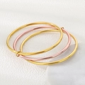 Close-up of three interlocking 3mm stainless steel bangles in gold and rose gold finish - 3 Rings (1 Rose Gold + 2 Gold)