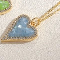 Blue shell mosaic heart pendant necklace with gold zircon frame on white background - Sapphire Blue
