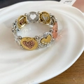 Dettaglio del bracciale elastico a tre colori con cuori e strass su un vassoio bianco - Stile Rilievo a Cuore Tricolore / Oro-Argento-Oro Rosa
