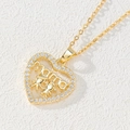 Detailed close-up of a 18k gold heart pendant featuring MAMA letters and child figures - Heart Mama/Two Children Figures/White Zirconia