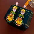 Dettaglio macro di orecchini a goccia con zirconi colorati su una scatola da gioielli - Oro Multicolore (Perno in Argento S925)